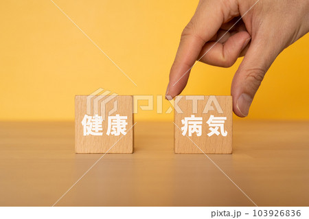 病気と書かれたブロックを選ぶ手 103926836
