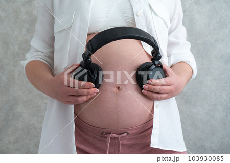 Unrecognizable Pregnant Woman Holding Wireless Headphones Near Belly,  Playing Music To Baby Stock Photo by Prostock-studio