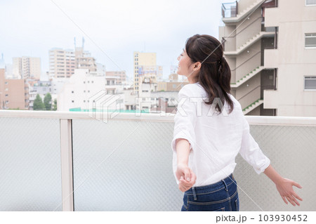 ベランダで深呼吸する若い女性 ベランダで深呼吸する若い女性 103930452
