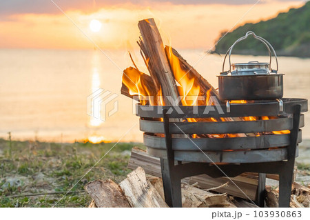 焚き火 焚き火台 キャンプファイヤー 炎 海岸 サンセット  夕日 夕焼け  キャンプギア  湯沸か 103930863