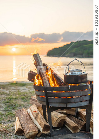 焚き火 焚き火台 キャンプファイヤー 炎 海岸 サンセット  夕日 夕焼け  キャンプギア  湯沸か 103930867