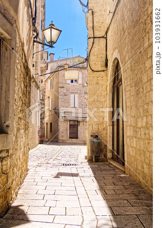 Narrow street with stone houses. Old houses and old narrow alley in Trogir, Croatia, Europe 103931662