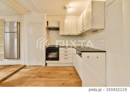a kitchen with white cabinets and black counter tops in the center of the photo is an oven, stove, sink, and dishwasher 103932119