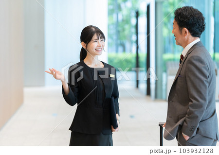 客を案内するホテルスタッフ 103932128