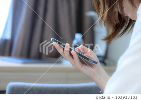 ベッドに座ってスマホを使用している女性 ビジネス ベッドに座ってスマホを使用している女性 ビジネス 103933103