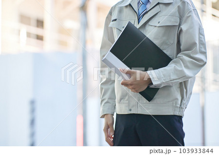 建設現場で書類を見る作業服の男性 103933844