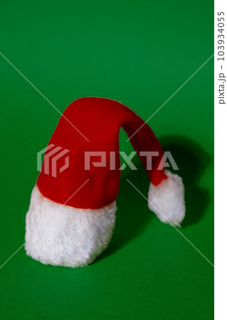 Santa hat on isometric green red background. Copy space for your text. Mock up for advertisement. Holiday Christmas composition. Minimalistic greeting card 103934055