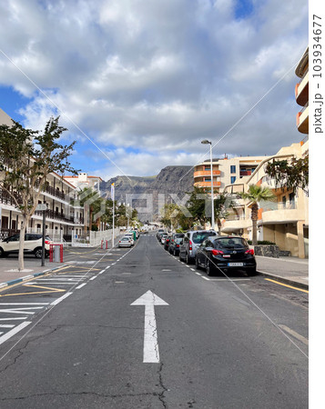 One side road with the road sign on it. Street with parallel parked cars. One side road with the road sign on it. Street with parallel parked cars. 103934677