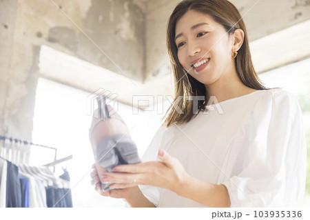スポーツアパレルショップで靴を見る若い女性 スポーツアパレルショップで靴を見る若い女性 103935336