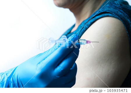 doctor's hand holds a syringe and a blue vaccine bottle at the hospital. Health and medical concepts. 103935471