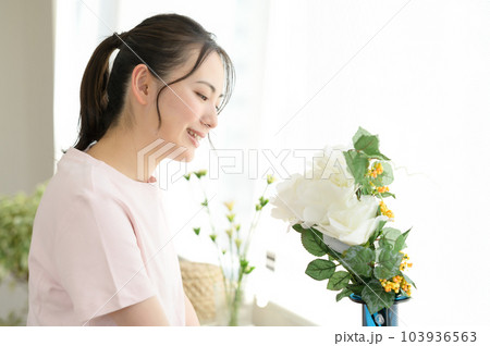 窓際の花を見る女性 103936563