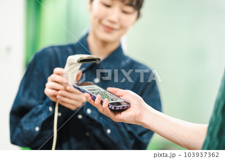 QRコードで支払いをする男性とコードをスキャンする女性店員 QRコードで支払いをする男性とコードをスキャンする女性店員 103937362