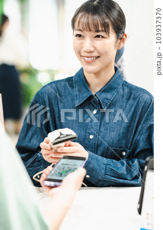 QRコードで支払いをする男性とコードをスキャンする女性店員 QRコードで支払いをする男性とコードをスキャンする女性店員 103937370