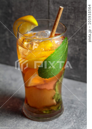 Cocktail with mint, ginger, and lemon on a grey background. 103938564