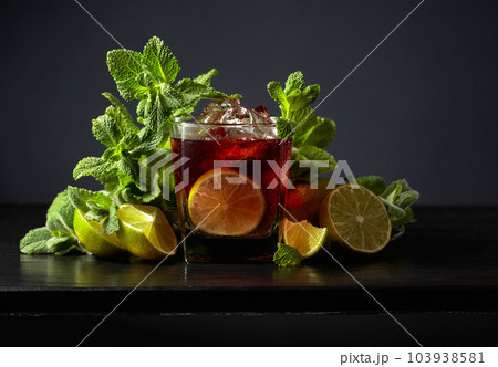 Cocktail Cuba Libre with rum, cola, mint, and lime on a black background. 103938581