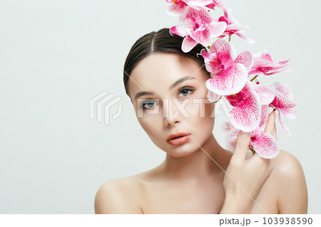 Beautiful Woman and Flowers. Beauty Portrait of Girl with Orchid flowe 103938590