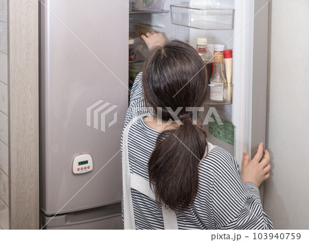 【冷蔵室を物色する主婦】 103940759