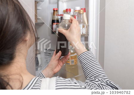 【冷蔵室からソースを出す主婦】 【冷蔵室からソースを出す主婦】 103940782