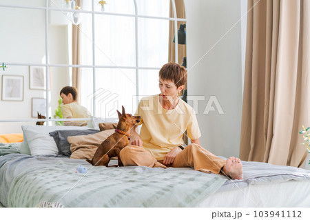 Dog training teams. Happy woman training pet at home in living room, playing Dog training teams. Happy woman training pet at home in living room, playing 103941112