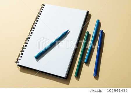 Close up of notebook and four markers with copy space on yellow background 103941452
