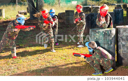 Group of laughing kids playing paintball Group of laughing kids playing paintball 103944041