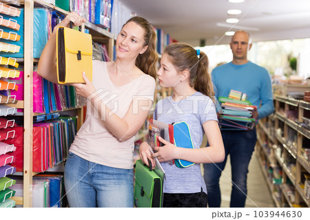 parents and daughter selecting school stationery parents and daughter selecting school stationery 103944630