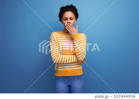 tired latin young woman with afro hair yawns 103944936