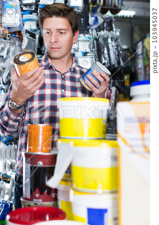 Worker selling tins of paint Worker selling tins of paint 103945037
