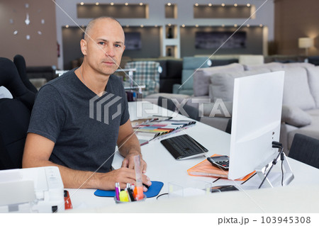 Sales consultant working with computer in furniture shop 103945308