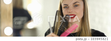 Portrait of woman hairdresser holding combs and scissors Portrait of woman hairdresser holding combs and scissors 103945821