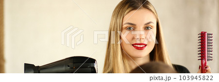 Woman hairdresser is holding hair dryer and comb man is sitting in chair 103945822