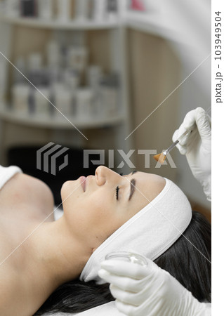 Reveal the secrets of effective facial skin peeling in this photo, which shows skin care and rejuvenation in a professional salon. Feeling of relaxation and freshness in a woman during the procedure Reveal the secrets of effective facial skin peeling in this photo, which shows skin care and rejuvenation in a professional salon. Feeling of relaxation and freshness in a woman during the procedure 103949504