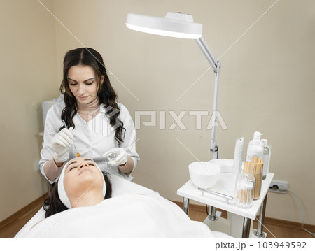 Consider this photo fragment to feel harmony and relaxation during the facial skin peeling procedure in a beauty salon with a professional cosmetologist and dermatologist. Cosmetology and cosmetics Consider this photo fragment to feel harmony and relaxation during the facial skin peeling procedure in a beauty salon with a professional cosmetologist and dermatologist. Cosmetology and cosmetics 103949592