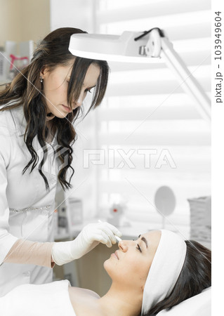 Youth in every moving detail: botulinum therapy helps a woman to maintain adolescence, revealing beauty in every gesture and facial expression. Professional cosmetologist does procedure cosmetology Youth in every moving detail: botulinum therapy helps a woman to maintain adolescence, revealing beauty in every gesture and facial expression. Professional cosmetologist does procedure cosmetology 103949604