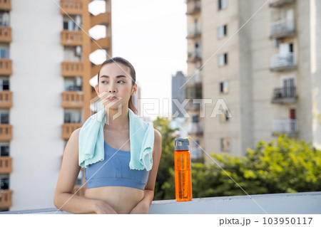 Young Asian woman resting after running exercise.outdoor exercise fitness concept 103950117