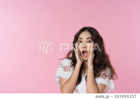 Young Asian woman doing a shocked surprise gesture shouting with hands cupped around mouth isolated pink color background 103950157