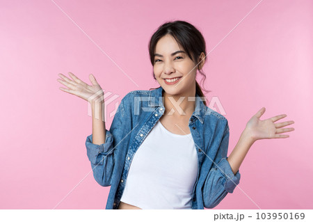 Young woman with surprise facial expression gesture with open palms over isolated pink background 103950169