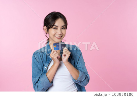 Young Asian woman showing blank credit card in formal suit, isolated pink background Young Asian woman showing blank credit card in formal suit, isolated pink background 103950180