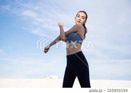 Young beauty Asian woman stretching workout outdoor rooftop. She warming up Young beauty Asian woman stretching workout outdoor rooftop. She warming up 103950194