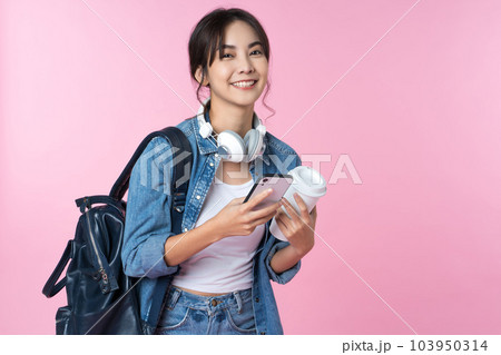 Portrait of young Asian woman student standing with smartphone coffee and backpack.College Teenager University concept. Portrait of young Asian woman student standing with smartphone coffee and backpack.College Teenager University concept. 103950314