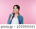 Yoing Asian woman talking on the phone holds cellphone making answering call on isolated pink background 103950341