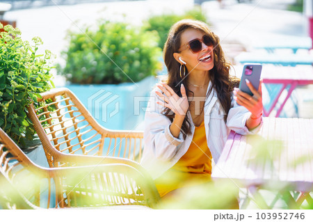 Young woman with shopping bags using her phone on the city street. Online shopping concept. Young woman with shopping bags using her phone on the city street. Online shopping concept. 103952746