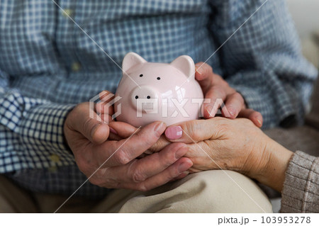 Saving money investment for future. Senior adult mature couple hands holding piggy bank with money coin. Old man woman counting saving money planning retirement budget. Investment banking concept 103953278