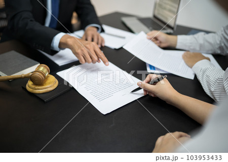 Legal counsel presents to the client a signed contract with gavel and legal law. justice and lawyer concept Legal counsel presents to the client a signed contract with gavel and legal law. justice and lawyer concept 103953433