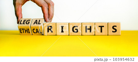 Ethical or legal rights symbol. Businessman turns wooden cubes and changes words ethical rights to legal rights on a beautiful white background. Business, ethical or legal rights concept. Copy space. Ethical or legal rights symbol. Businessman turns wooden cubes and changes words ethical rights to legal rights on a beautiful white background. Business, ethical or legal rights concept. Copy space. 103954632