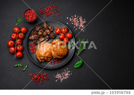 Delicious juicy chicken thighs baked with salt, spices and herbs in a ceramic plate 103956788