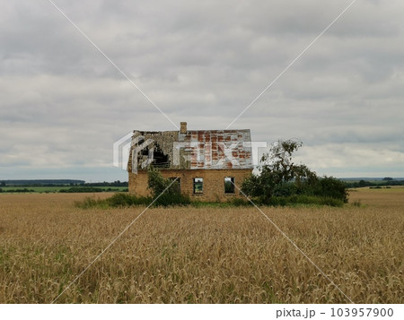 Old brick farmhouse in the countryside with storm clouds in the sky. 103957900