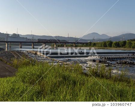 青空が広がる大和川の柏原堰堤と鉄道の風景 103960747
