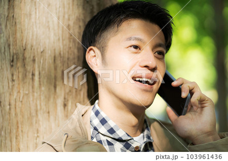 自然の中でスマホを持つ男性の写真 自然の中でスマホを持つ男性の写真 103961436