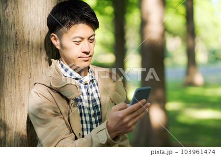 自然の中でスマホを持つ男性の写真 103961474